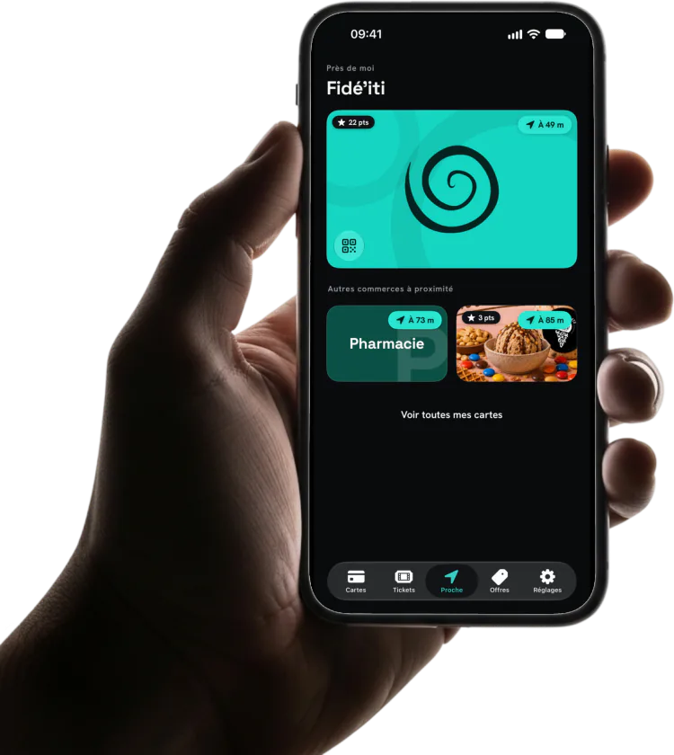 Main tenant un iPhone : onglet Proche, carte Fidé’iti prête à être présentée